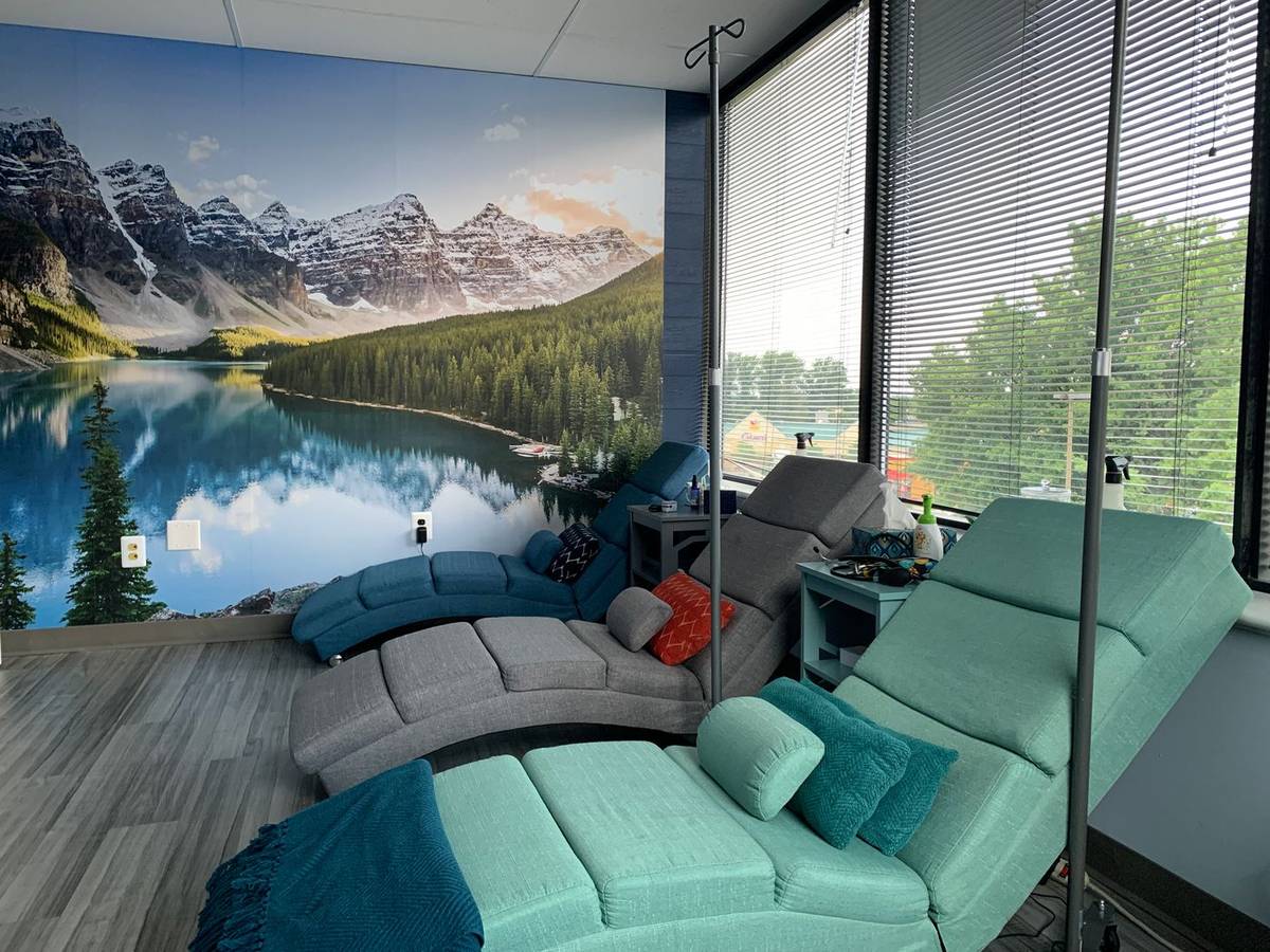 Sunlit reclining chairs and a peaceful mountain mural inside our Columbia clinic.
